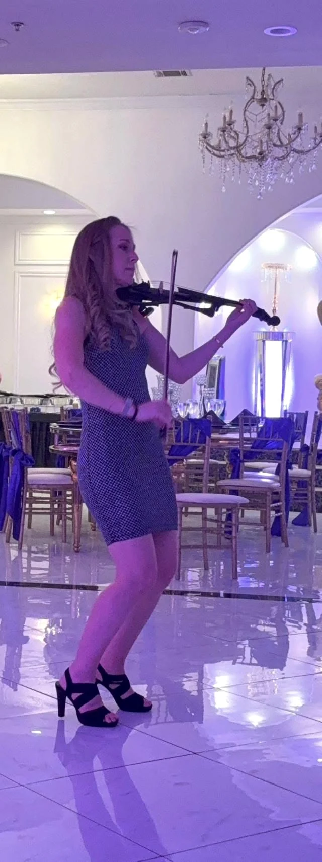 Melani X.O. performing violin at an elegant private event