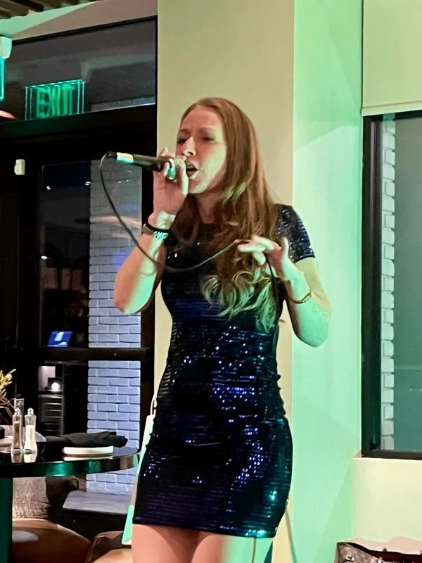 Melani X.O. singing at an upscale private event